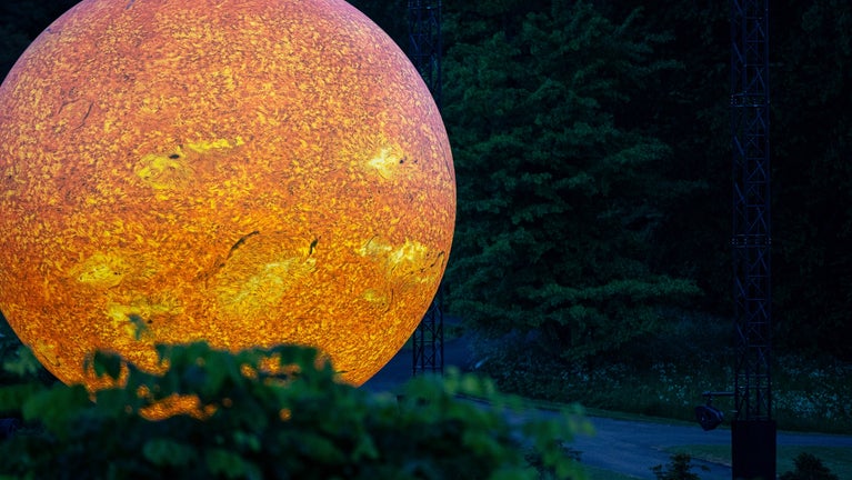 Image of Helios, a sculpture by Luke Jerram, displayed outdoors at night